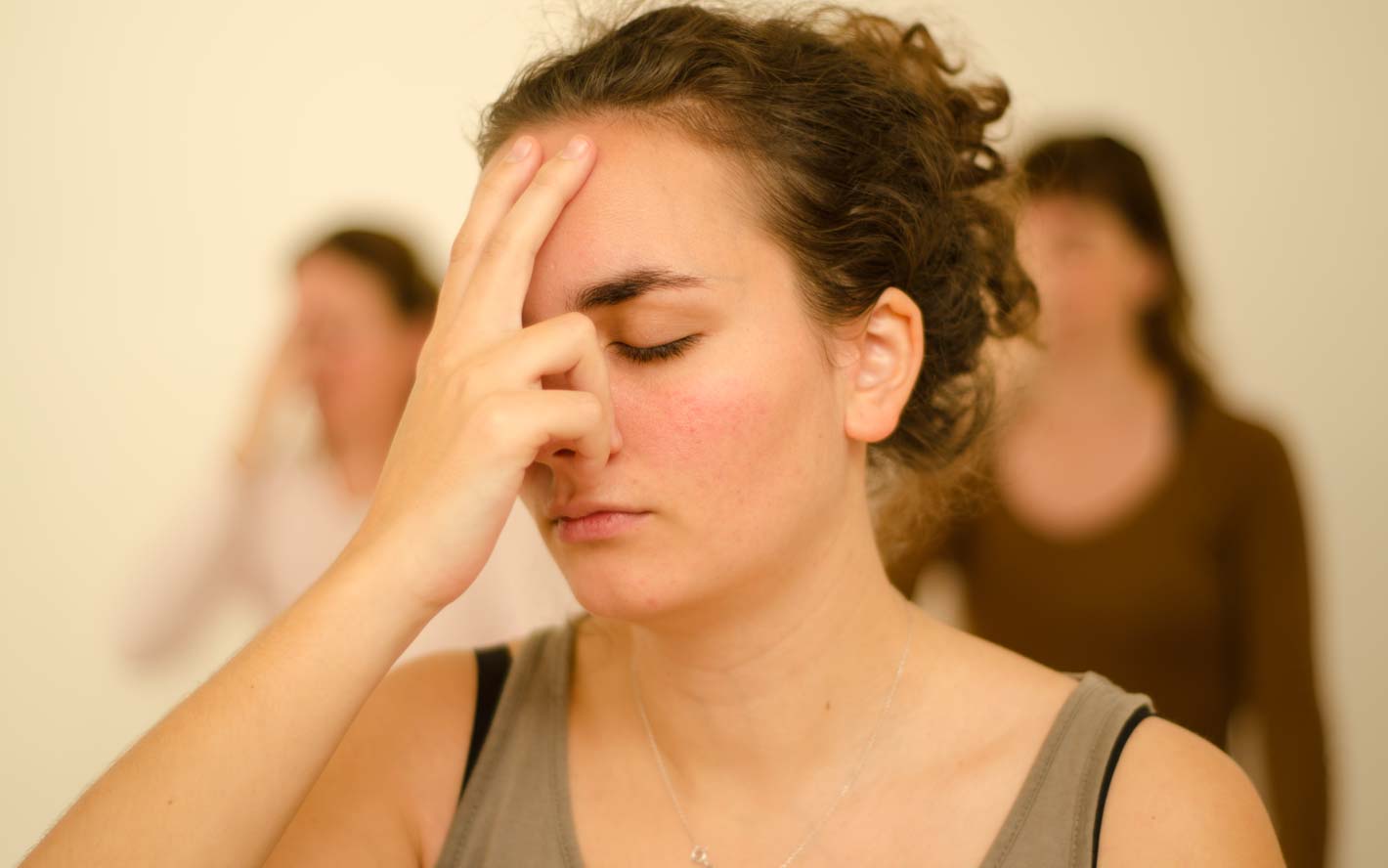 Jeune fill pratiquant nadi shodhana durant un cours de yoga.