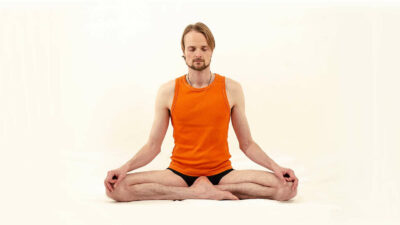 Homme assis dans sukhasana, la posture facile.