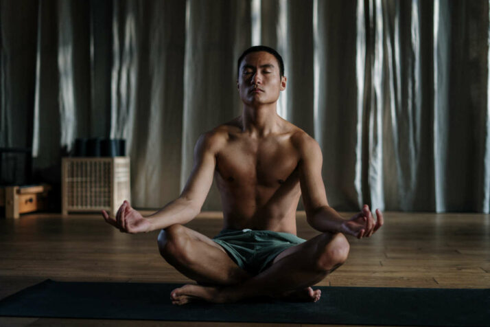 Jeune homme assis dans la posture du tailleur qui est une posture qui n'est pas propice à la méditation.