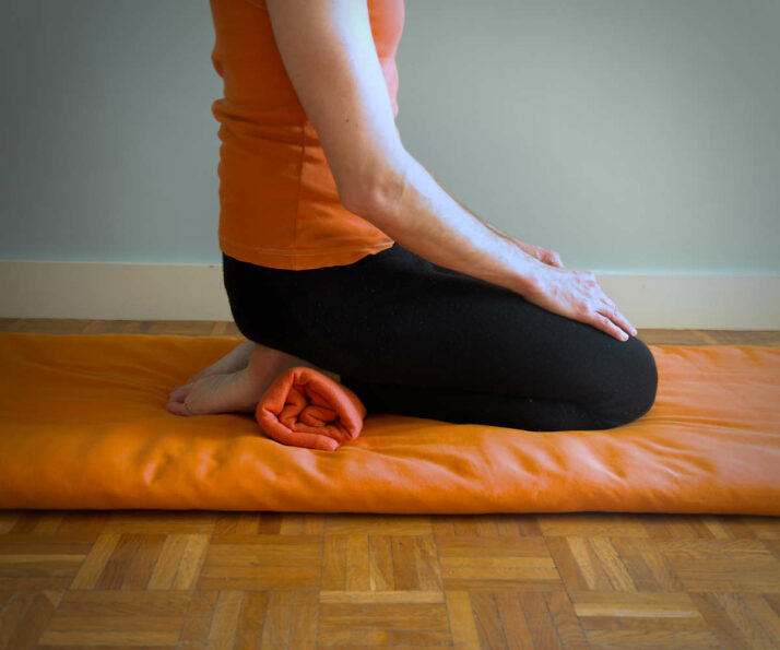 Adaptation de vajrasana avec un couverture sous les pieds.