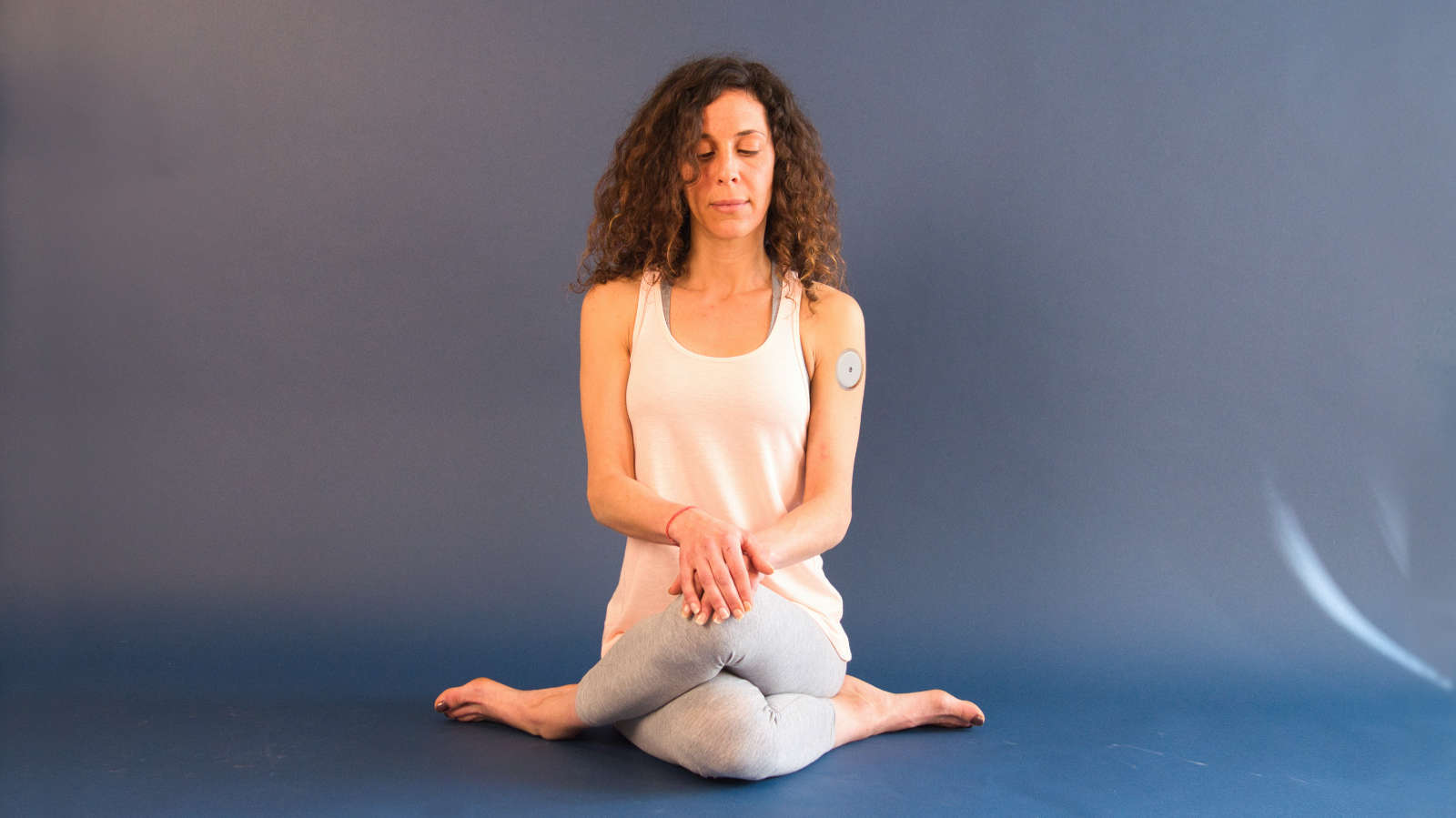 Posture de yoga avec capteur de glucose en continu pour le diabète.