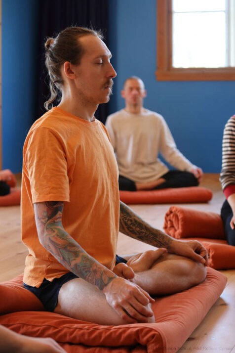 Homme en train de méditer durant une retraite de yoga et méditation.