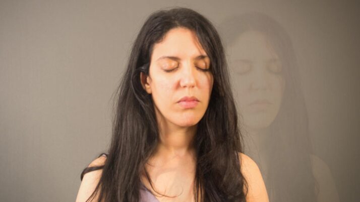 Femme en méditation avec un léger dédoublement de l’image illustrant une sensation de dissociation et de perte d’ancrage.