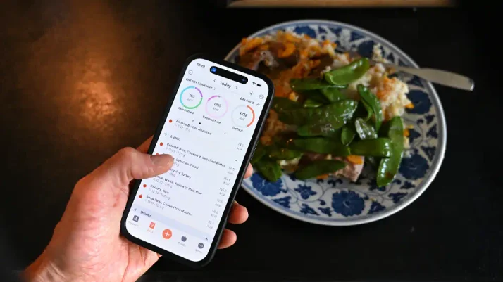 Repas accompagné d’un smartphone affichant une application de suivi alimentaire.